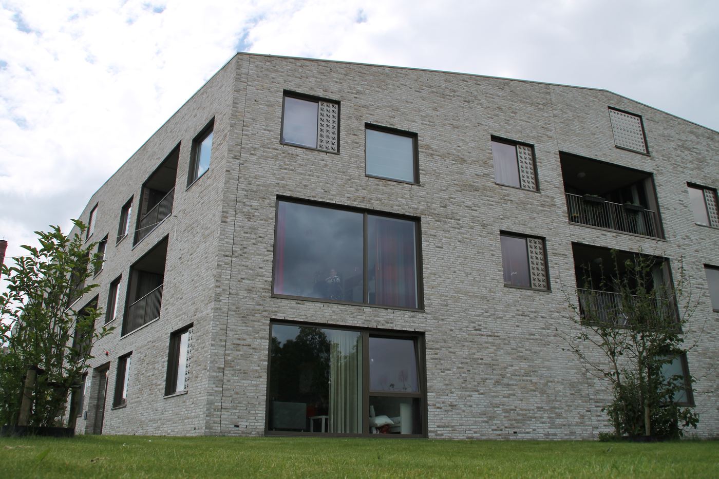 De oostzijde van het woongebouw van Schots & Scheef, met balkons en groene voortuinen